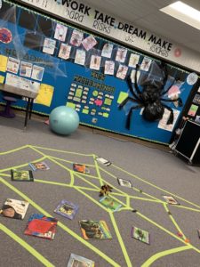 Example of spider classroom transformation with green web on ground along with library books