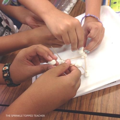 3 students working together with marshmallows and toothpicks during STEM class.