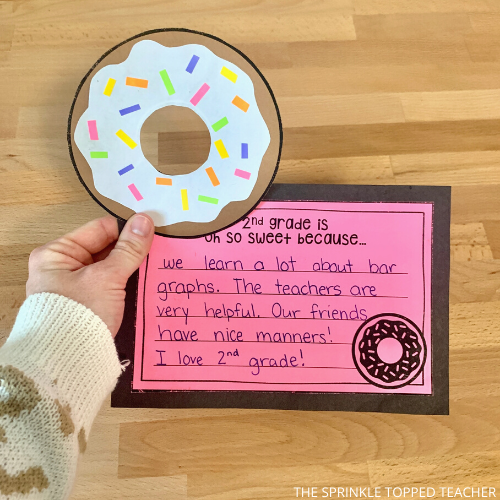 Student holding donut craft for Valentines Day writing activity