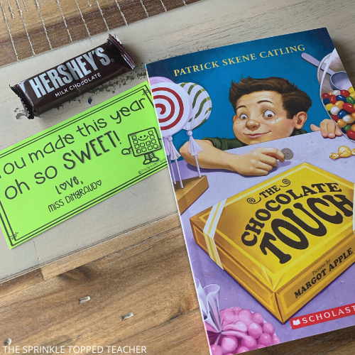 Book: The Chocolate Touch with Hershey bar and end of the year gift tag on wood table
