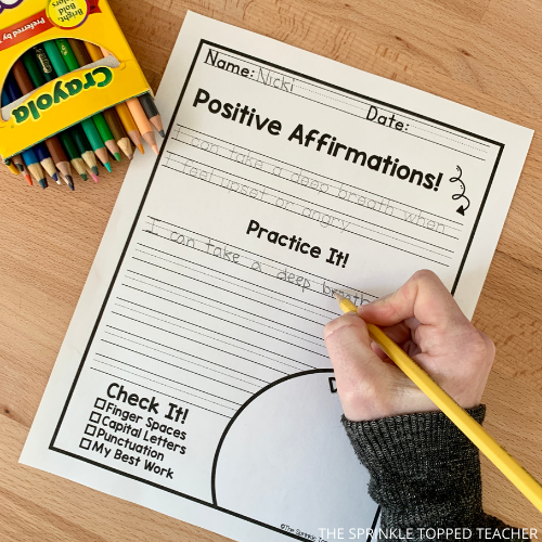 Student working on handwriting worksheet with crayola colored pencils