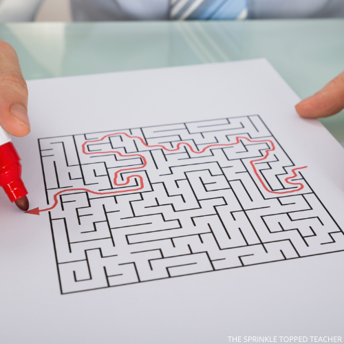 Student working on fine motor skills by drawing through a maze with a red marker