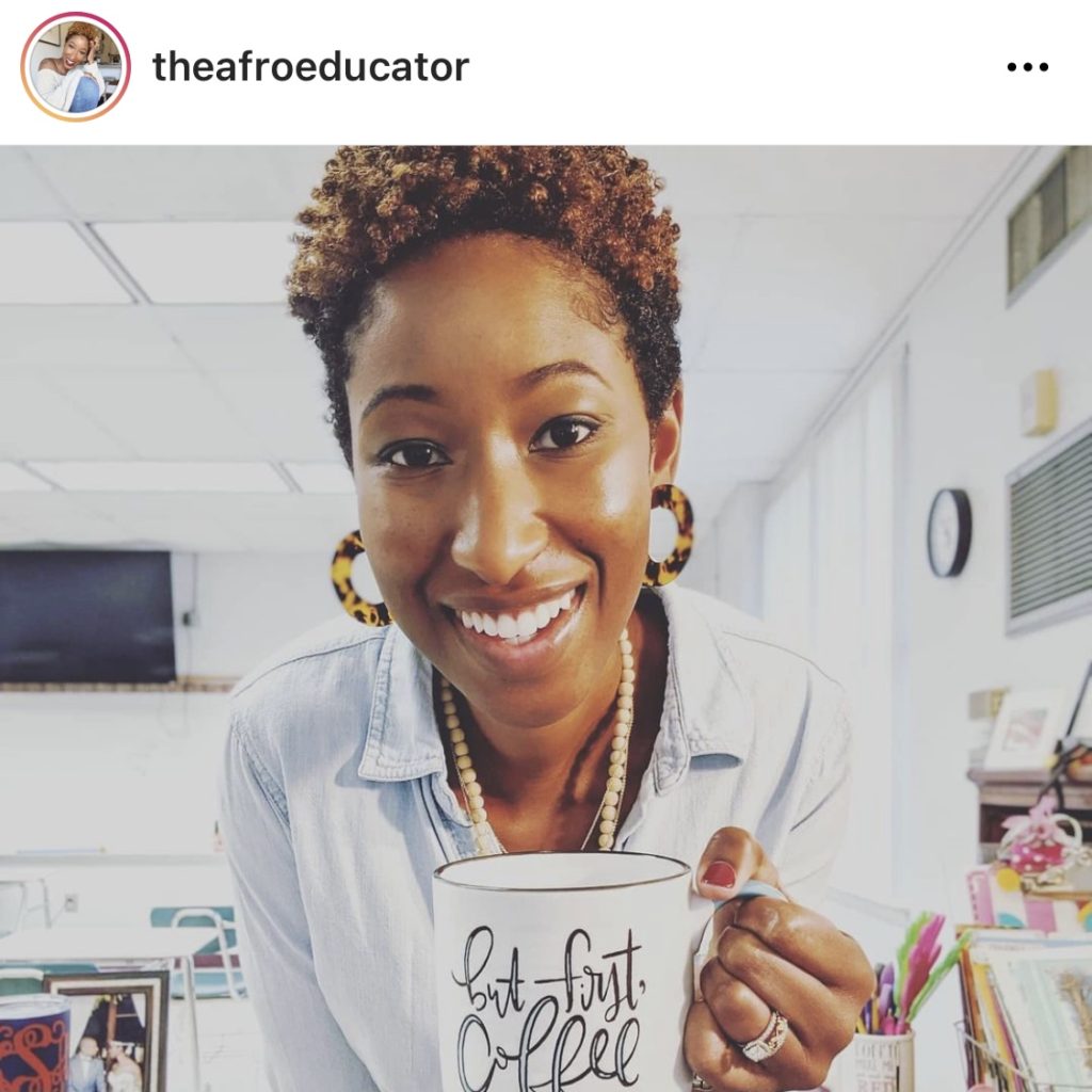 Teacher holding coffee mug in classroom @theafroeducator