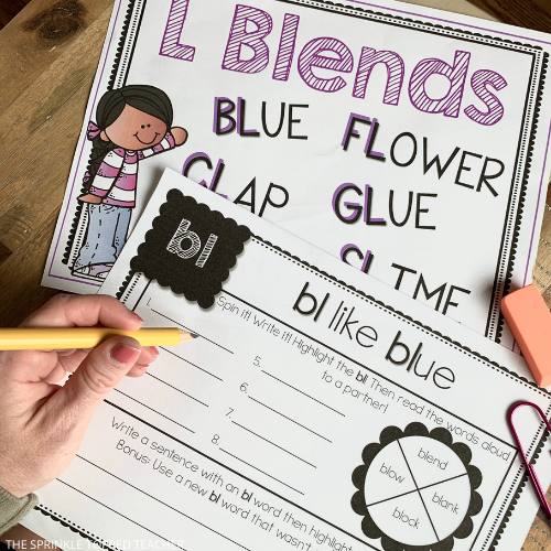student working on beginning blends worksheets with L blends anchor chart