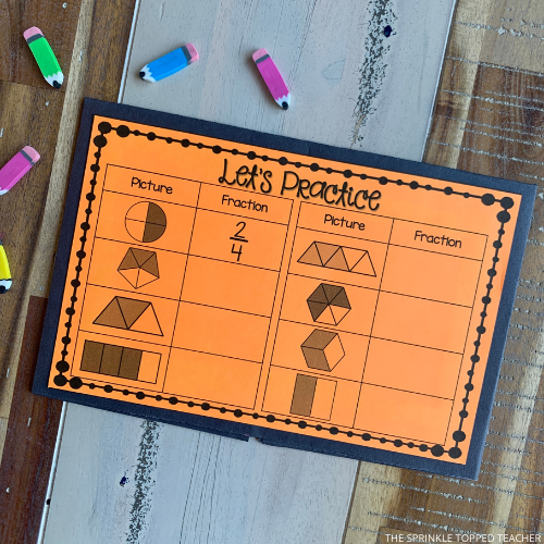 Orange half sheet to practice fractions. Students look at the shape broken into sections and write the correct fraction. There are colored mini erasers on the table.