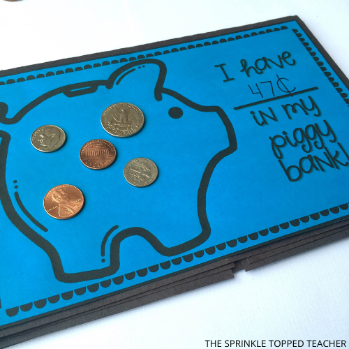 Blue half page with piggy bank from the money activity for second grade. Shows a quarter, two dimes and two pennies. The blank states that there are 47 cents in the piggy bank.