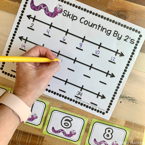 A student fill out their skip counting by 2s activity with a pencil.