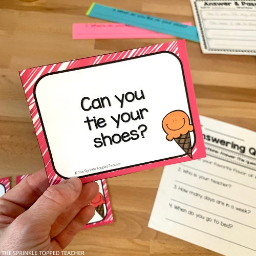 Student holding a Restate the Question task card.